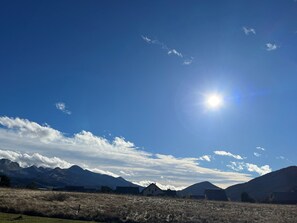 A mountainous landscape with a clear sky and the sun shining brightly.