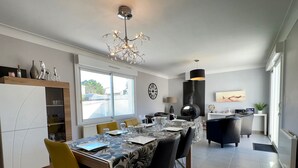 A modern dining area with a chandelier, a fireplace, and a view of the outside.