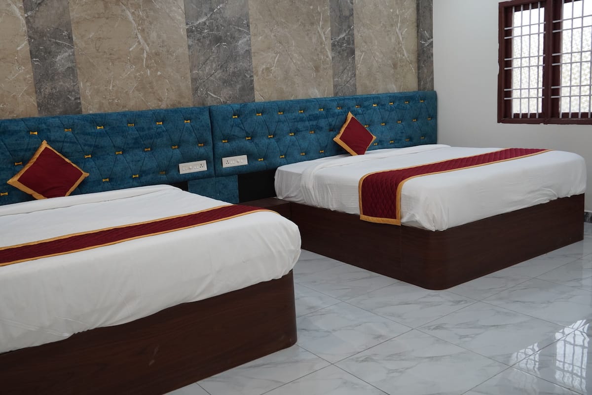 Habitación de hotel con dos camas, paredes de mármol y una ventana con rejas.