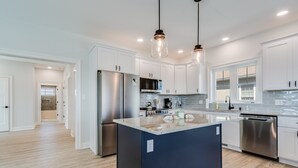 A modern kitchen with white cabinets, stainless steel appliances, and a central island. - 510 S. Bayshore Dr.- 4 Bedroom Waterfront home located in Broadkill Beach, with Spectacular Views! (Milton)
