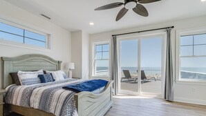 A bedroom with a bed, a ceiling fan, and a view of the ocean through large windows. - 510 S. Bayshore Dr.- 4 Bedroom Waterfront home located in Broadkill Beach, with Spectacular Views! (Milton)