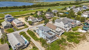 An aerial view of a coastal residential area with houses, a beach, and a lake. - 510 S. Bayshore Dr.- 4 Bedroom Waterfront home located in Broadkill Beach, with Spectacular Views! (Milton)