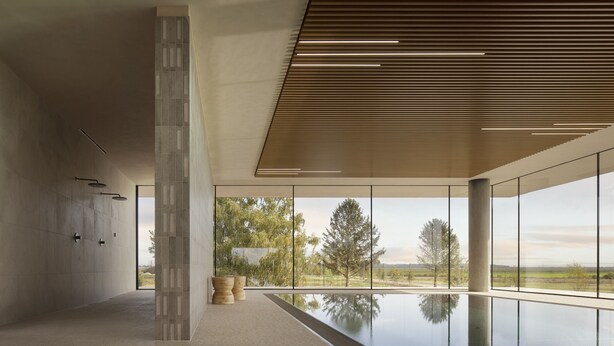A modern spa room with a large window, a pool, and a wooden ceiling. - Hotel Materra (Cepin)