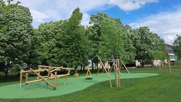 Explore the lush surroundings and enjoy the climbing frame and swings in this serene outdoor play area.