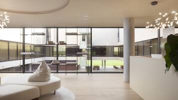 Un interior moderno con una zona de estar, un mostrador de recepción y vistas al exterior.