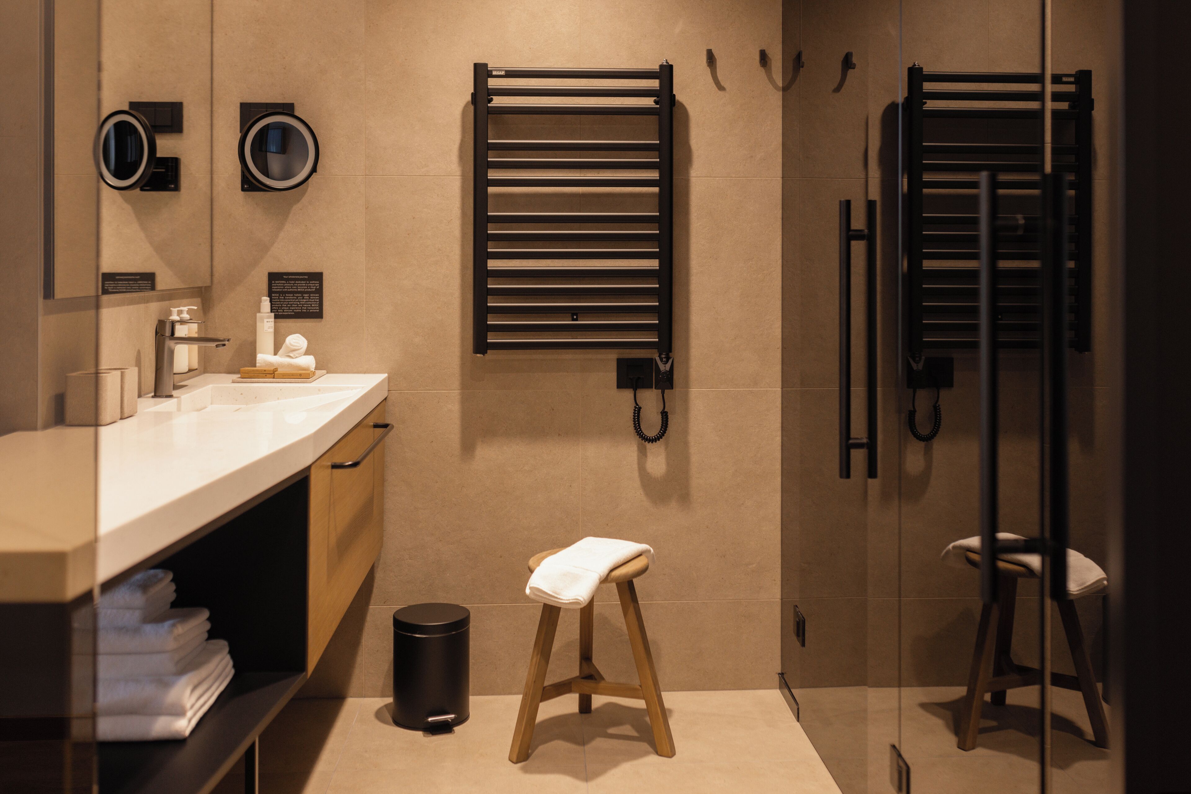 Une salle de bain moderne avec un meuble-lavabo, un porte-serviettes et un tabouret.