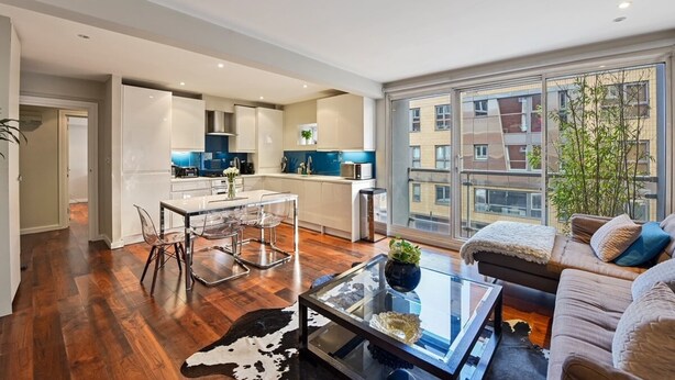 A modern apartment with a kitchen, dining area, and living room.