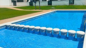 A swimming pool with a blue tiled deck and a series of white and blue floating barriers. - Ground Floor Apartment with Pool Access Near Beach in Miami Playa (Miami Playa)