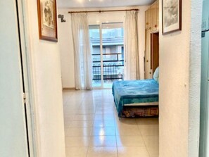 Relax in this inviting room with a large bed, sliding glass door to a balcony, and framed artwork on the walls.