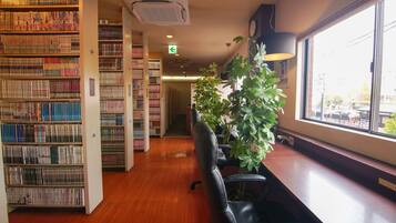 A library with bookshelves, a desk, and a large window.