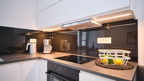 Uma cozinha moderna com fogão embutido, forno e máquina de café.