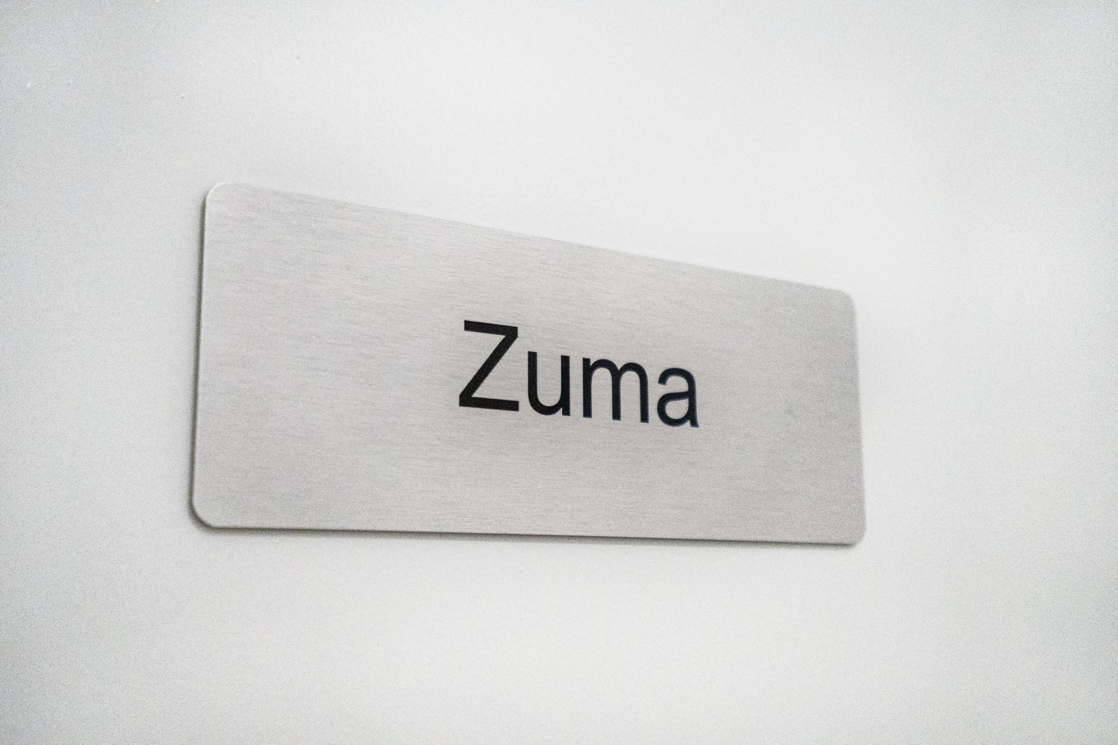 A metallic nameplate with the word "Zuma" on it.