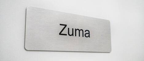 A metallic nameplate with the word "Zuma" on it.