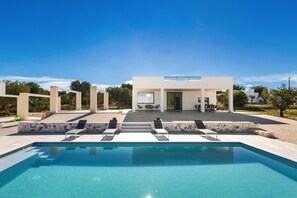 A modern house with a swimming pool, outdoor seating, and a patio area. - 3670 Villa Perlaianca by Perle di Puglia (Carovigno)