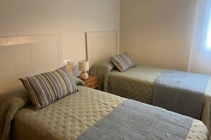 2 dormitorios, tabla de planchar con plancha, ropa de cama