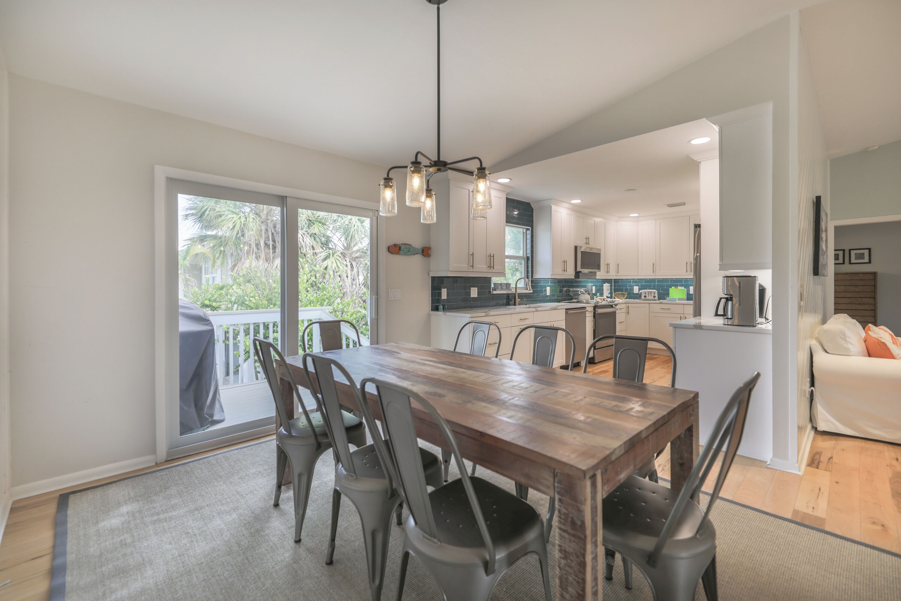 Una cocina moderna con una mesa y sillas de madera, una isla integrada y vistas al exterior.