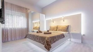 Une chambre à coucher moderne avec un grand lit, un miroir et des lampes de chevet.