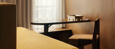 Une chambre d’hôtel moderne avec un mur d’accent en bois, une table à manger avec une chaise et un canapé.