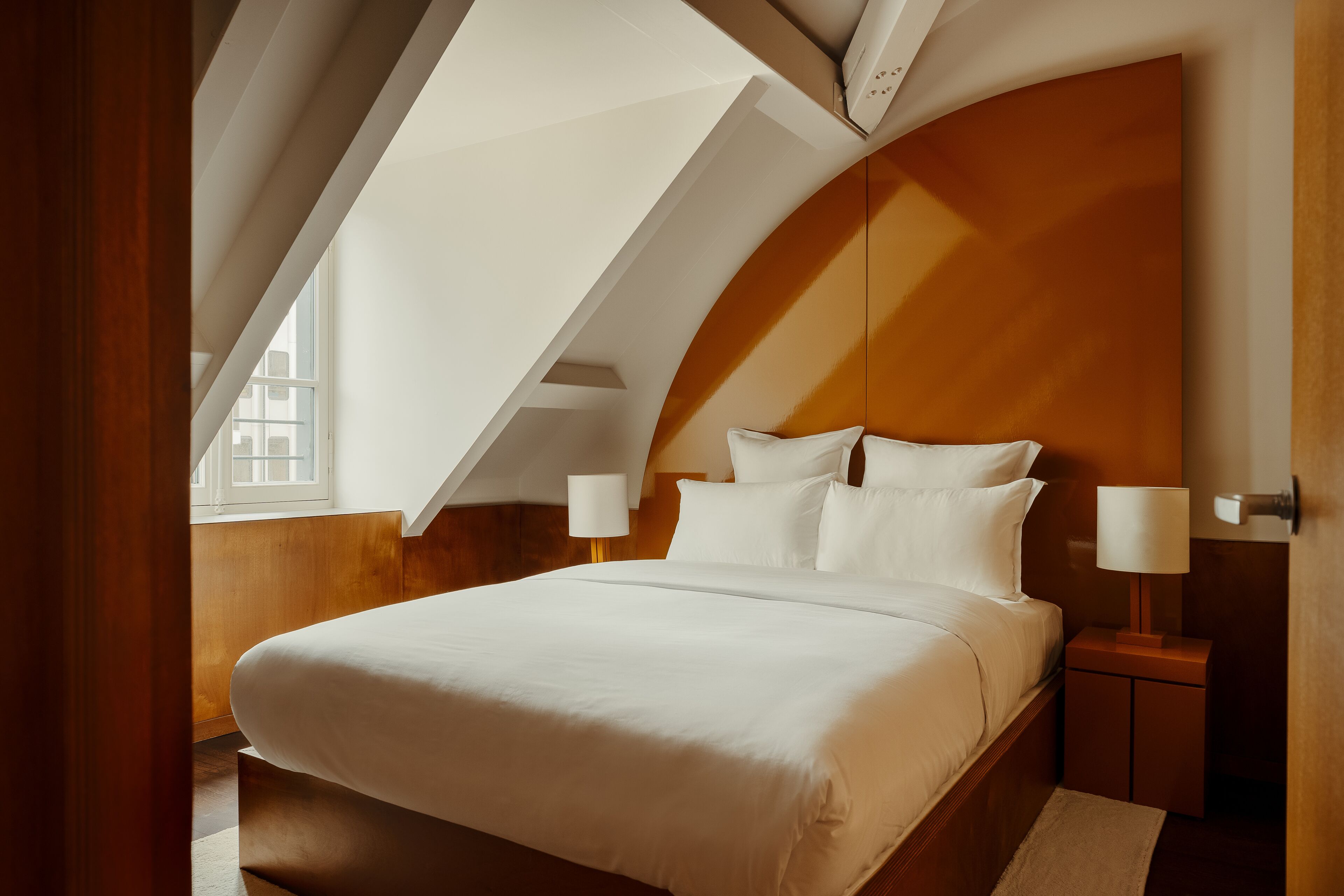 Ein Schlafzimmer mit einem großen Bett, zwei Nachttischen und einer gewölbten Decke.