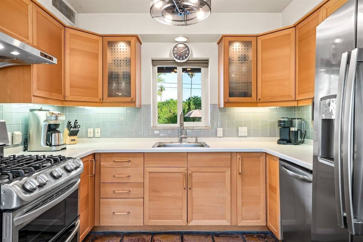 A modern kitchen with wooden cabinets, stainless steel appliances, and a central island.
