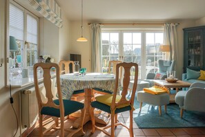 A dining area with a round table, chairs, and a view of the outdoors.