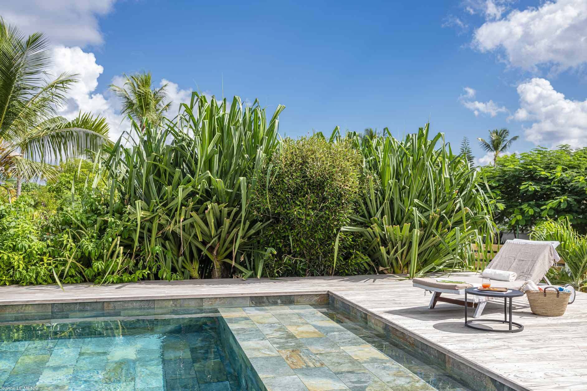 Una piscina al aire libre, sillones reclinables de piscina