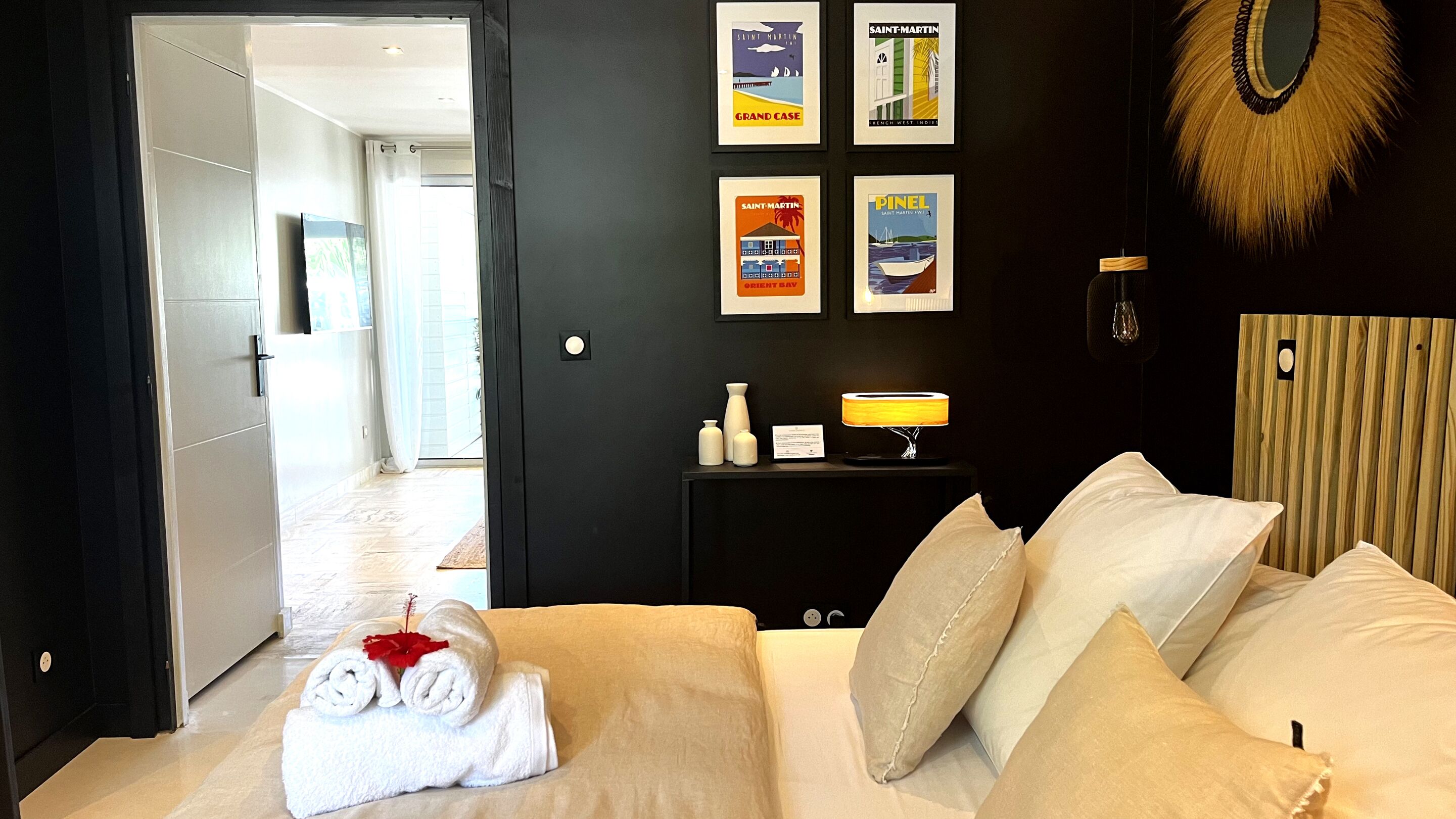 Une chambre d’hôtel avec un lit, une table de chevet avec une lampe et des affiches encadrées au mur.