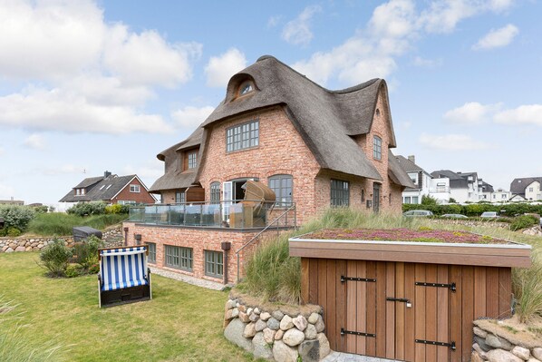 Une maison dotée d’une architecture originale, caractérisée par un toit en pente et une construction en briques.