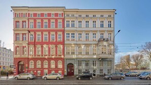 Une rangée d’immeubles à étages multiples, caractérisés par un style architectural uniforme, avec de grandes fenêtres et un toit plat.