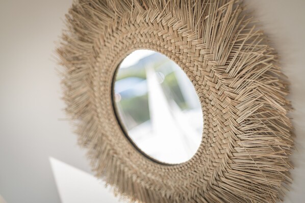 A woven circular mirror with a textured frame.