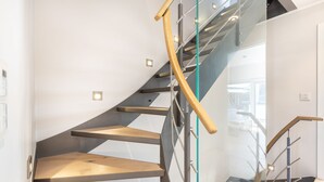 Eine moderne Treppe mit Glasgeländern und Holzbeschlägen.