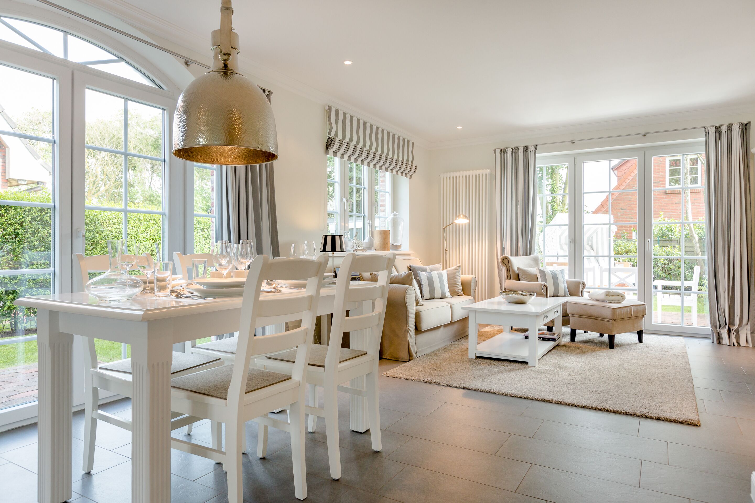 Un salón amplio con comedor, ventanas grandes y vistas al exterior.