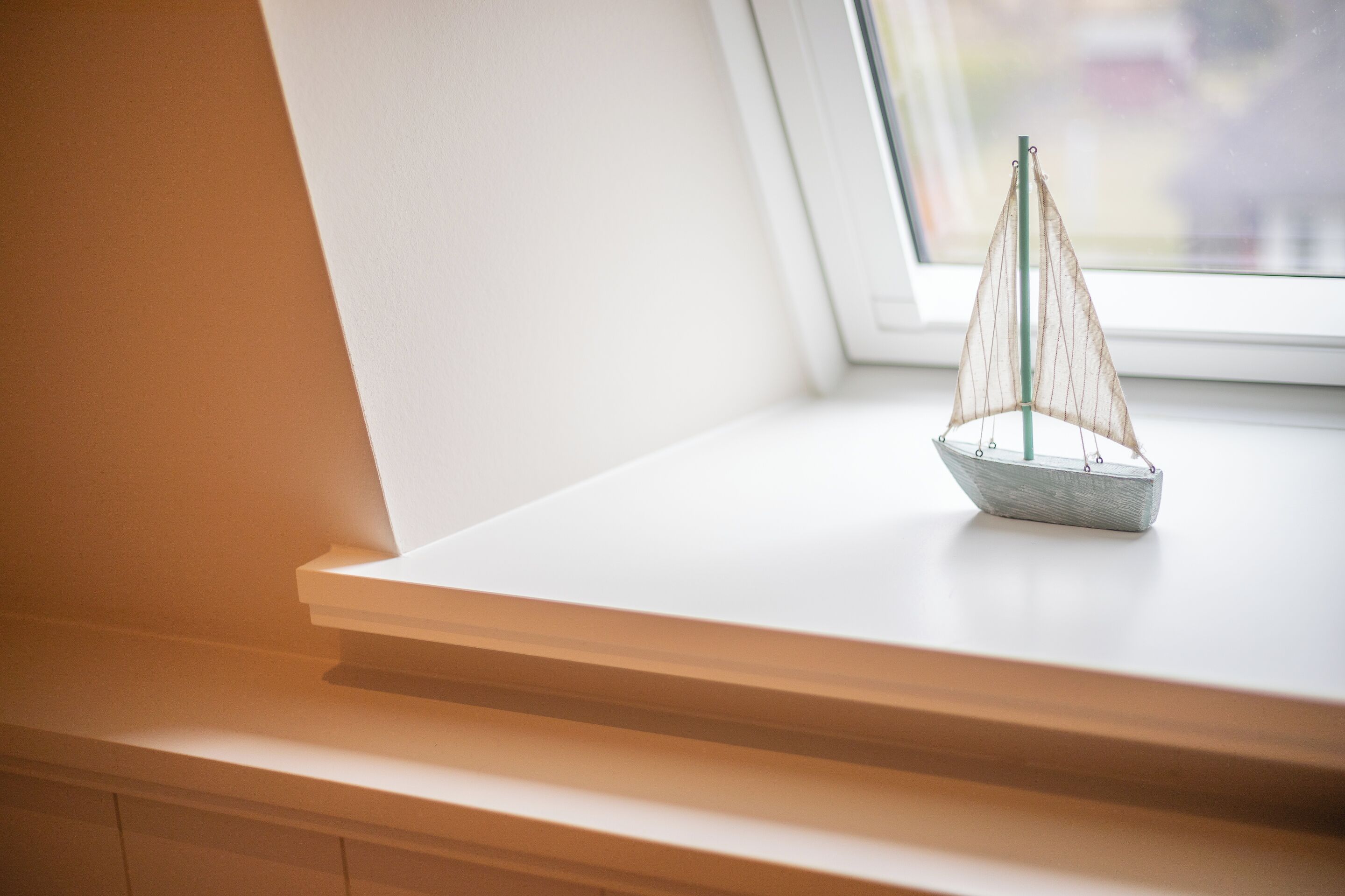 A model sailboat on a windowsill.