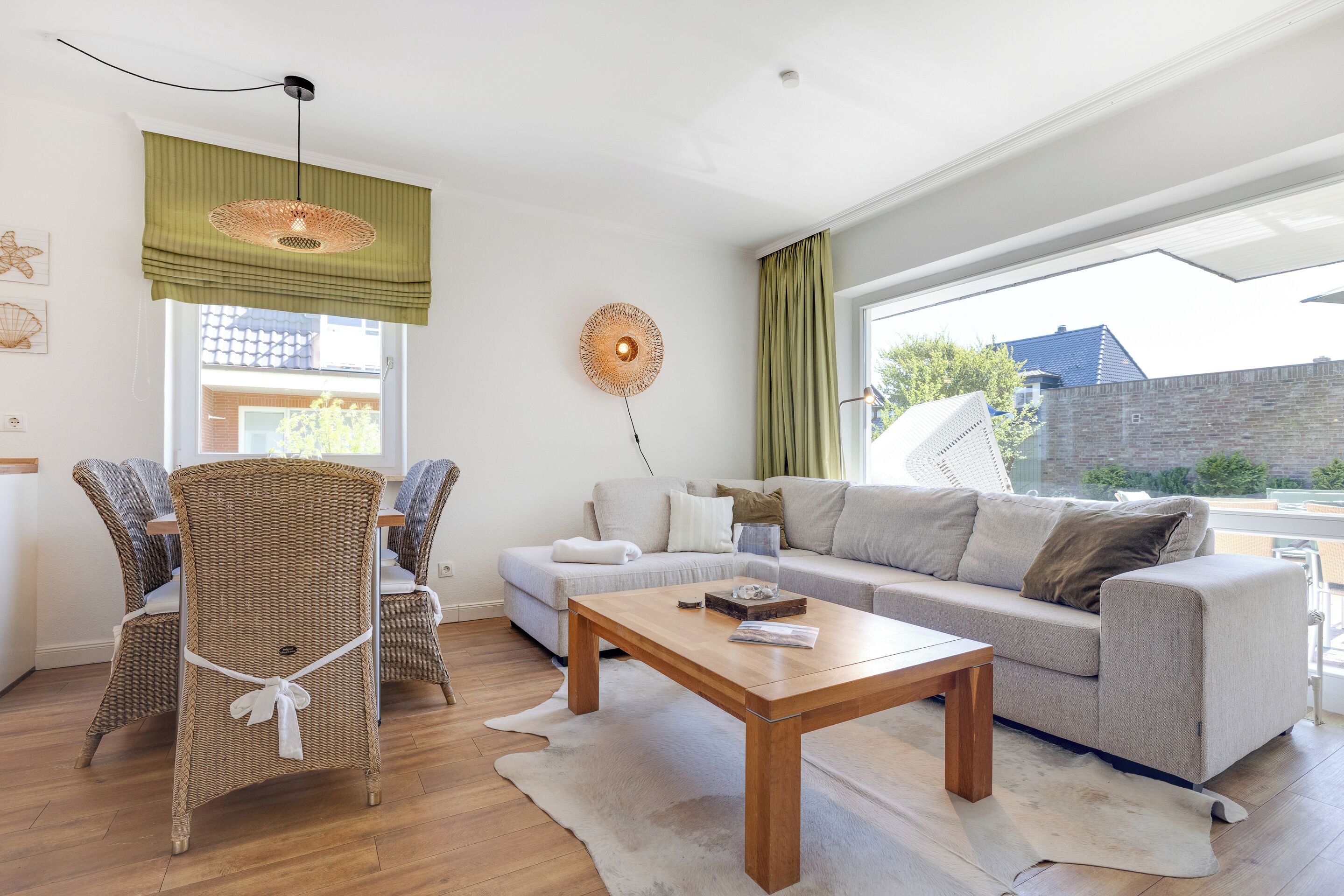 A modern living room with a sofa, chairs, a coffee table, and a large window with curtains.