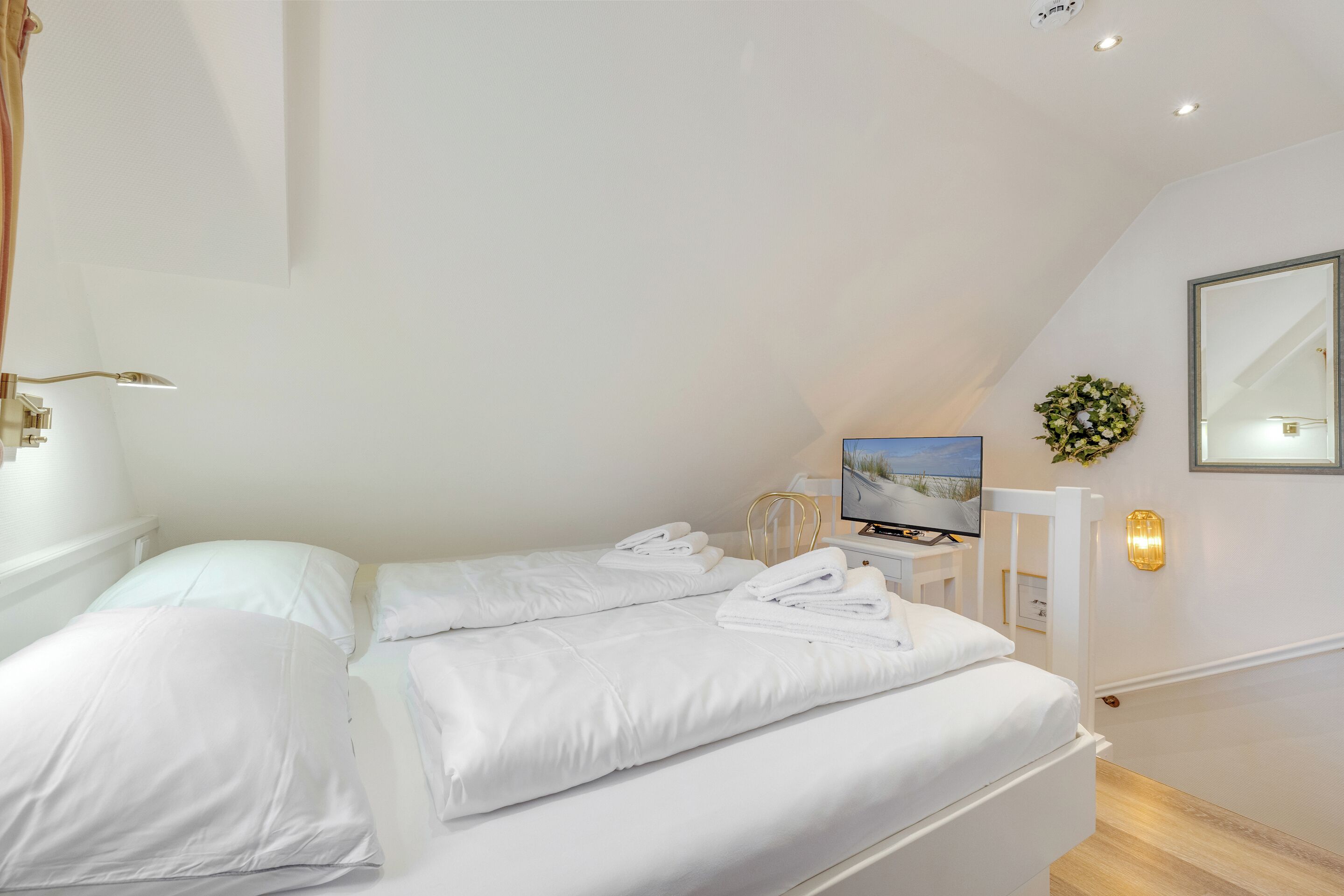 Een moderne hotelkamer met een bed, een televisie en een spiegel.