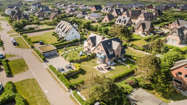 Ein Wohngebiet mit Häusern, einer Straße und Grünflächen.
