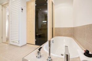 Une salle de bain moderne avec une baignoire sur pieds, un porte-serviettes et un espace douche.