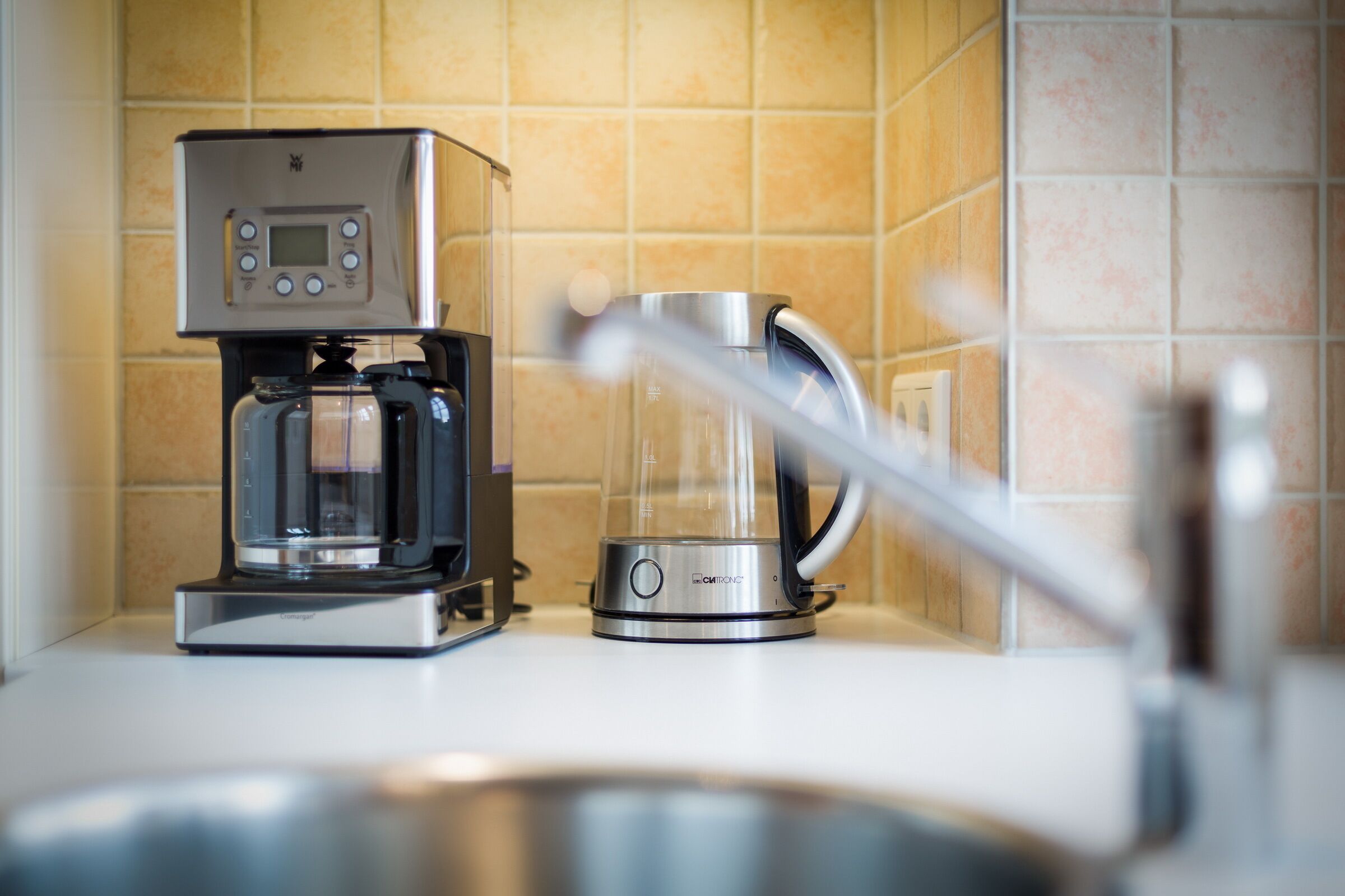 A coffee maker and a water dispenser on a kitchen counter.
