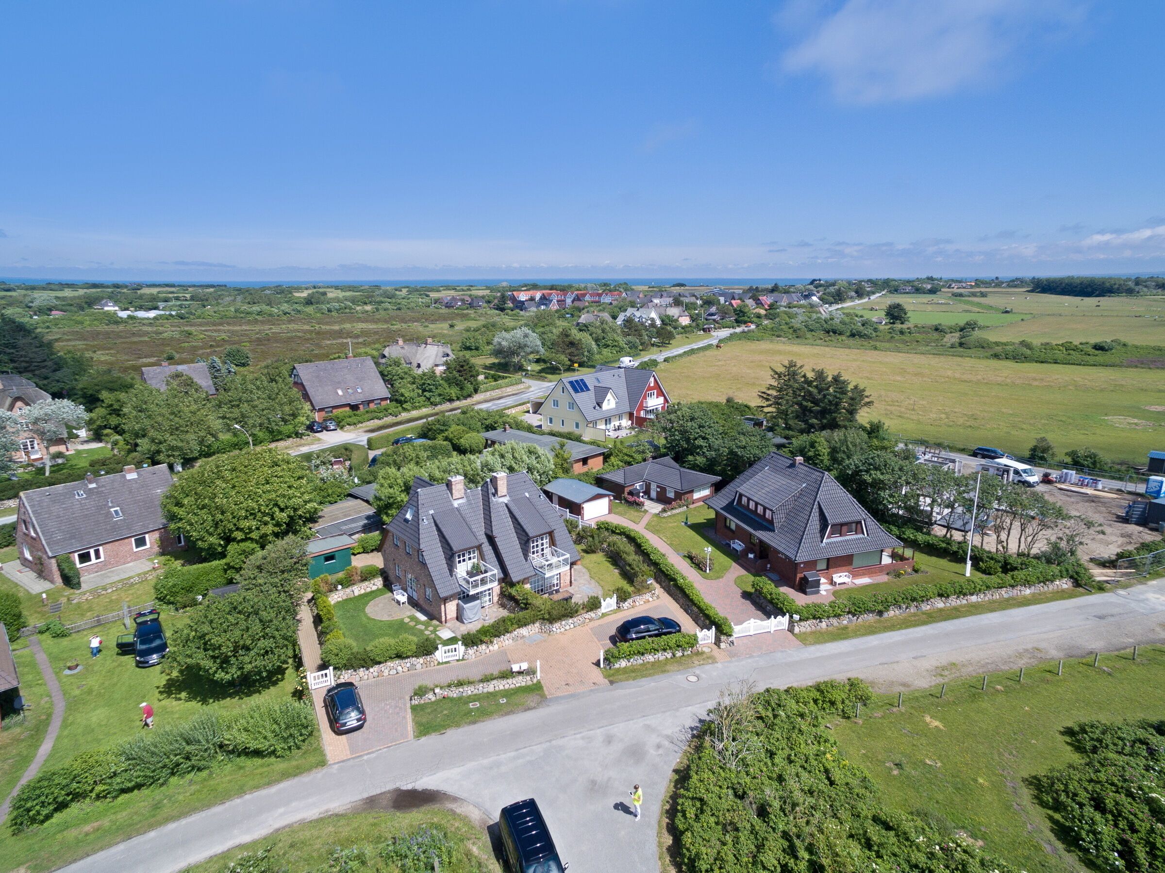 Una vista aerea di una zona residenziale con case, strade e aree verdi.