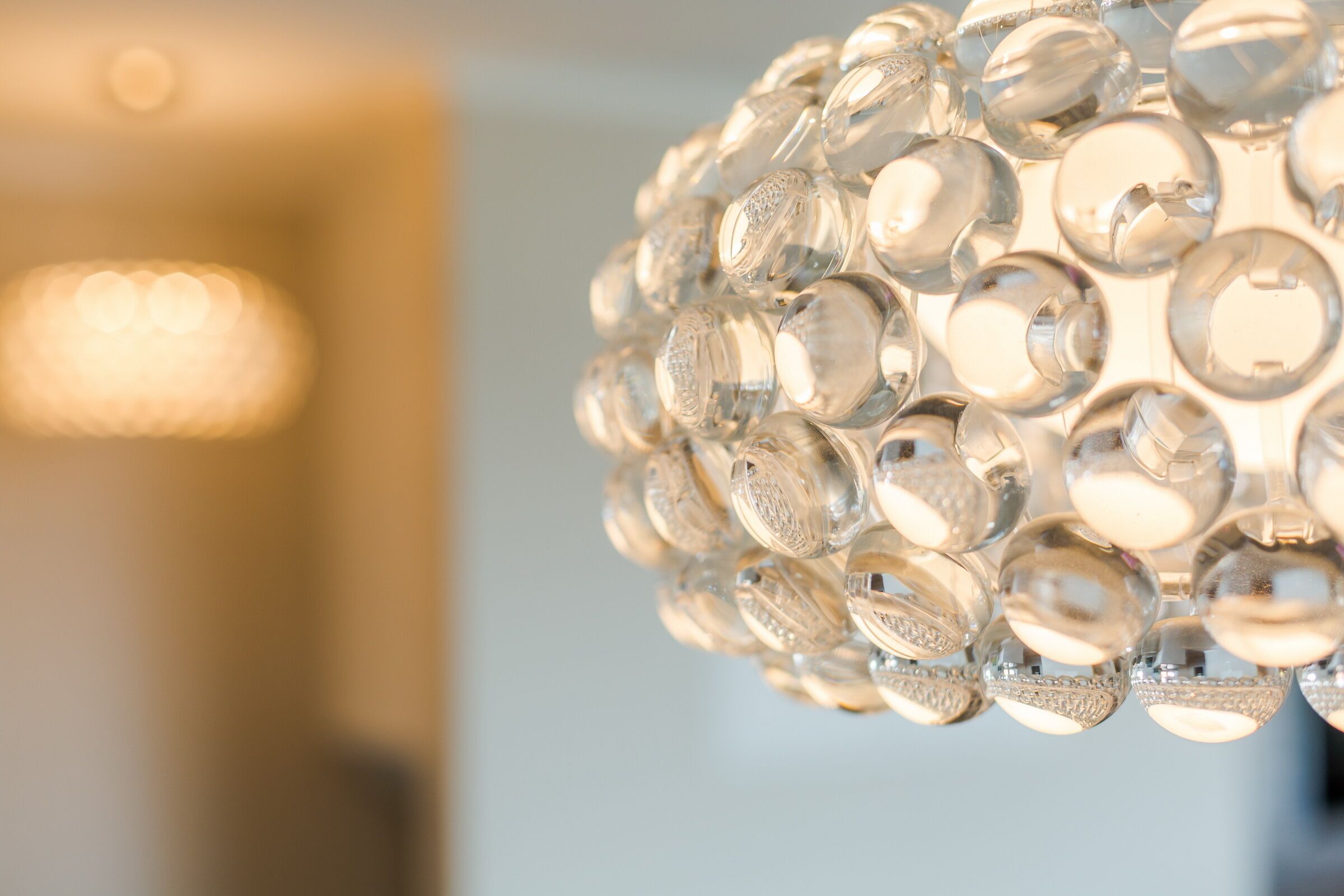 A close-up of a spherical chandelier with multiple clear glass bulbs.
