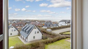 Um bairro residencial com casas, um campo gramado e um céu limpo.