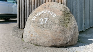A large stone with the inscription "STURMFried 27" on a paved surface.