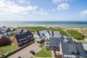 Un quartier résidentiel avec des maisons, une plage et un ciel dégagé.