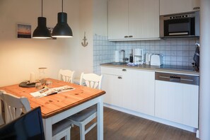 Cafetera o tetera, frigorífico, microondas y placa de cocina