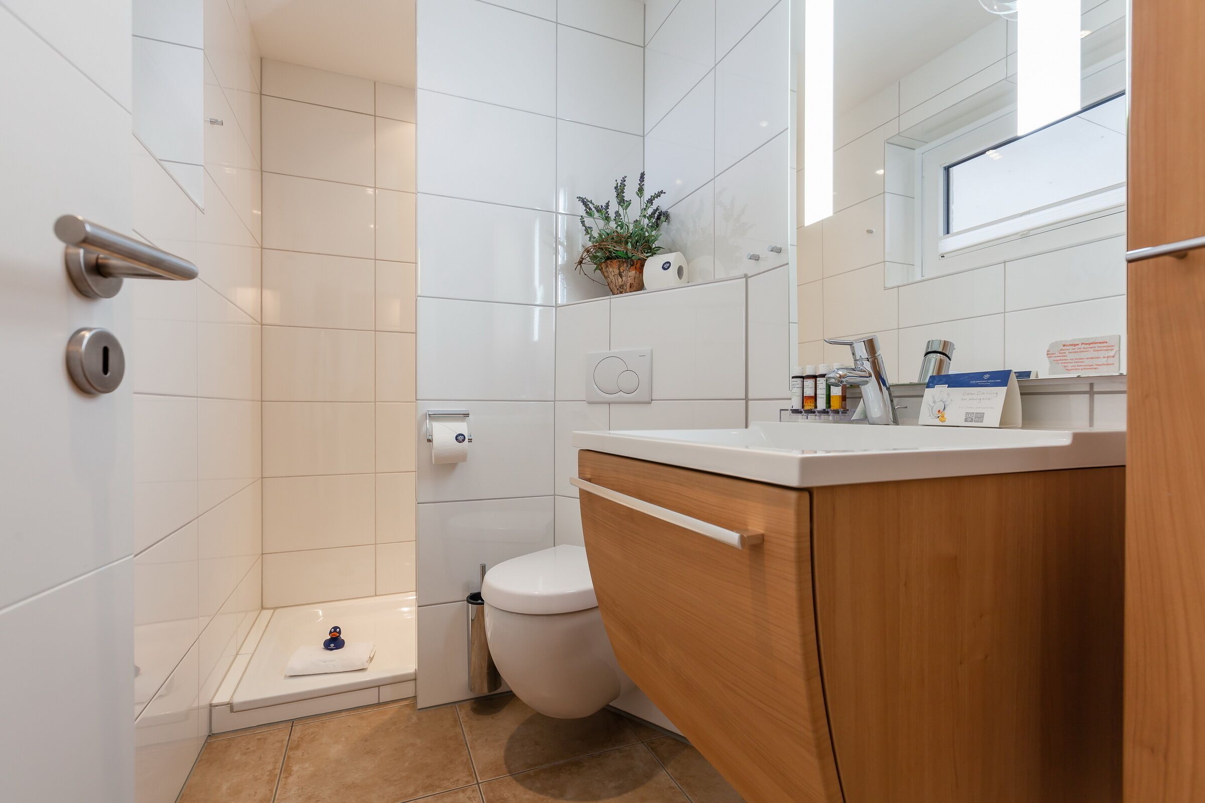 Ein modernes Badezimmer mit Toilette, Waschbecken und Dusche.