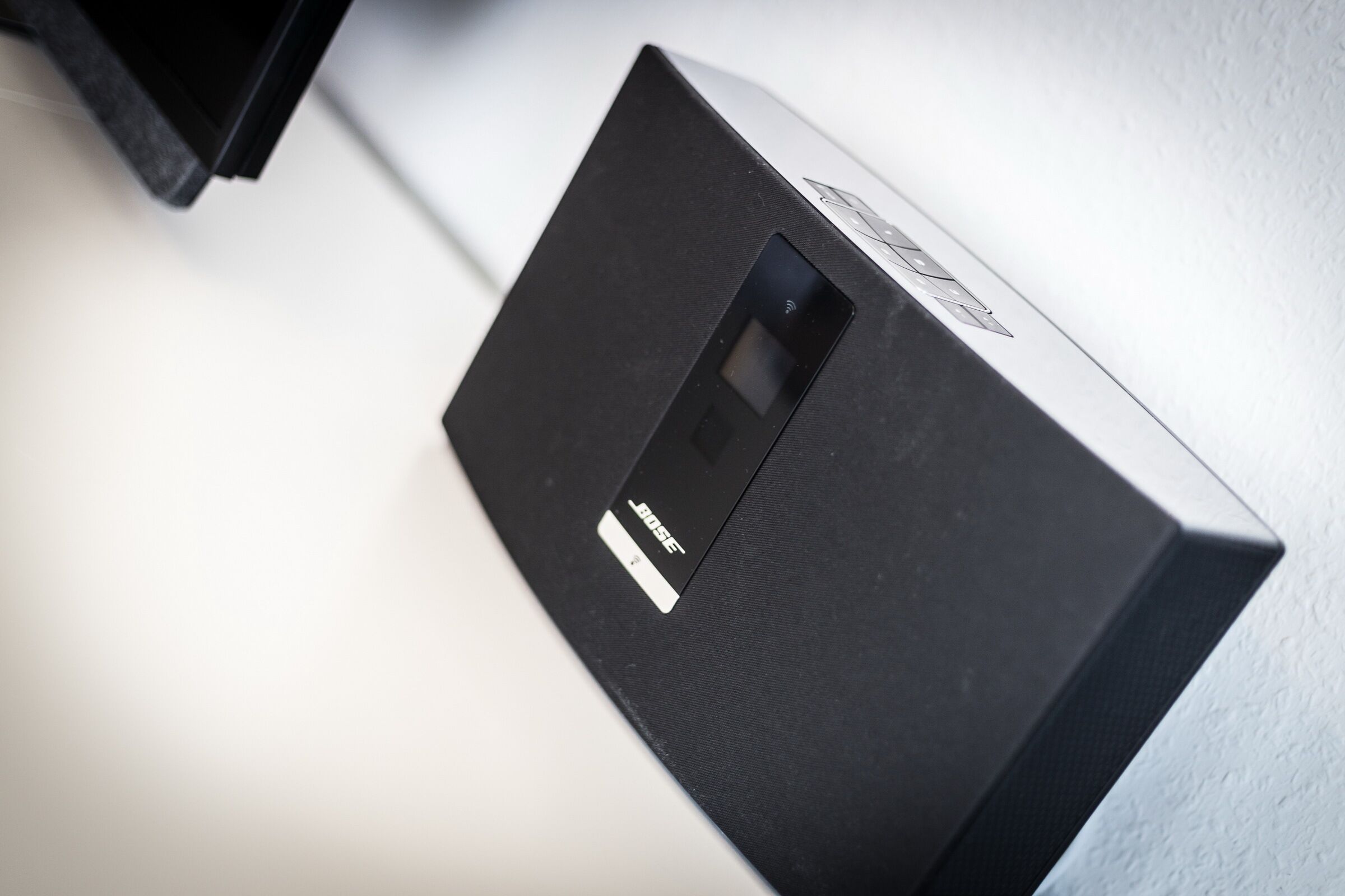 Un altavoz blanco y negro con panel de control y etiqueta.