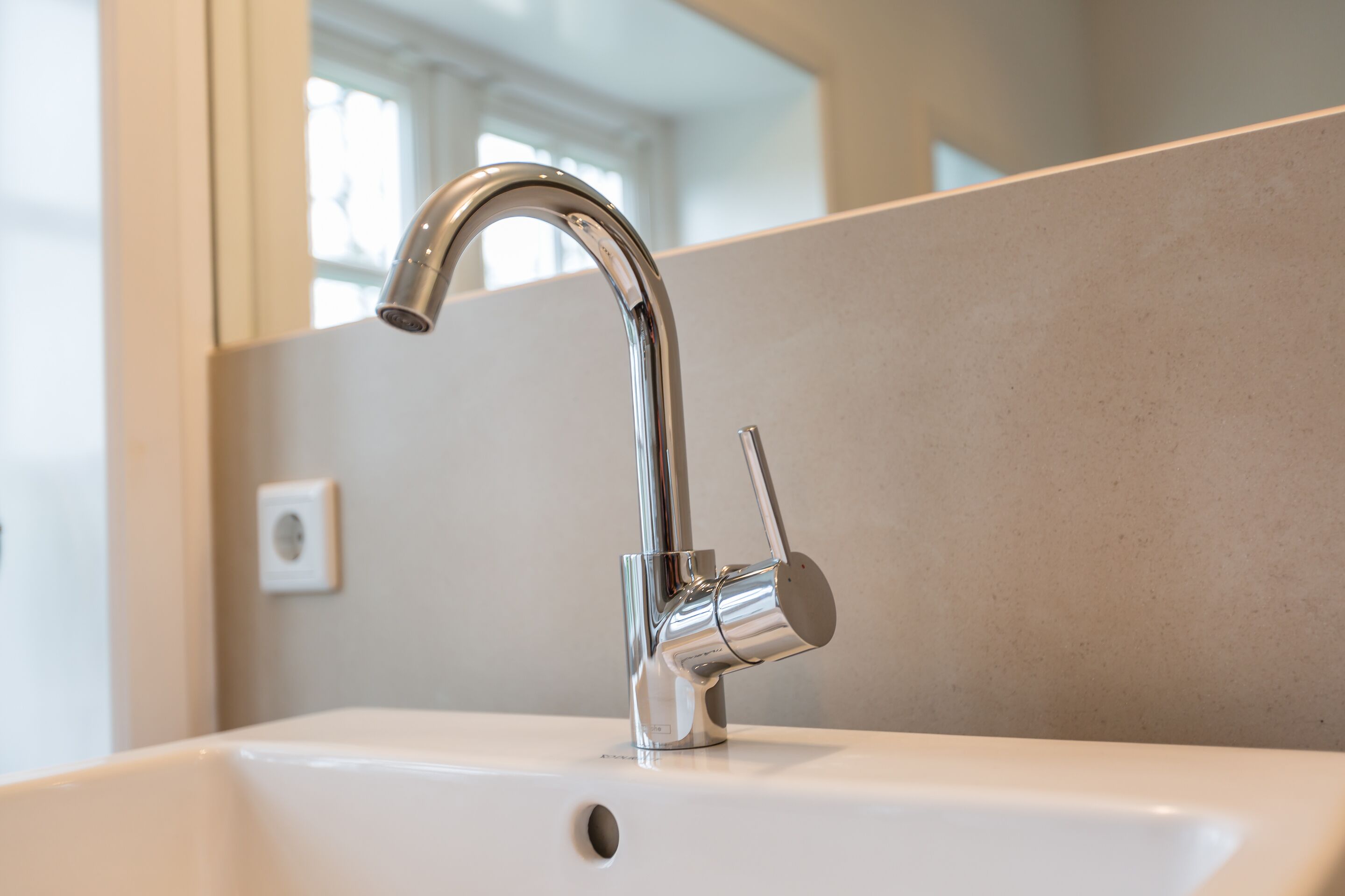 Ein modernes Waschbecken mit chromfarbenem Wasserhahn und Einhebelmischung.