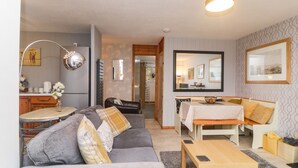 A modern living room with a grey sofa, wooden coffee table, and a dining area with a white table and chairs. - Manorcombe 40 (Gunnislake)