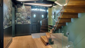 A modern interior with a wooden staircase, a fish wall mural, and a glass railing. - Das Traumhaus für Designliebhaber, Ästheten, Entschleuniger und Wahre Sylfans ! (Sylt)