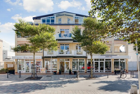 Een meerlaags gebouw met een winkel op de begane grond en een zichtbaar restaurant genaamd 'INDIWO'.